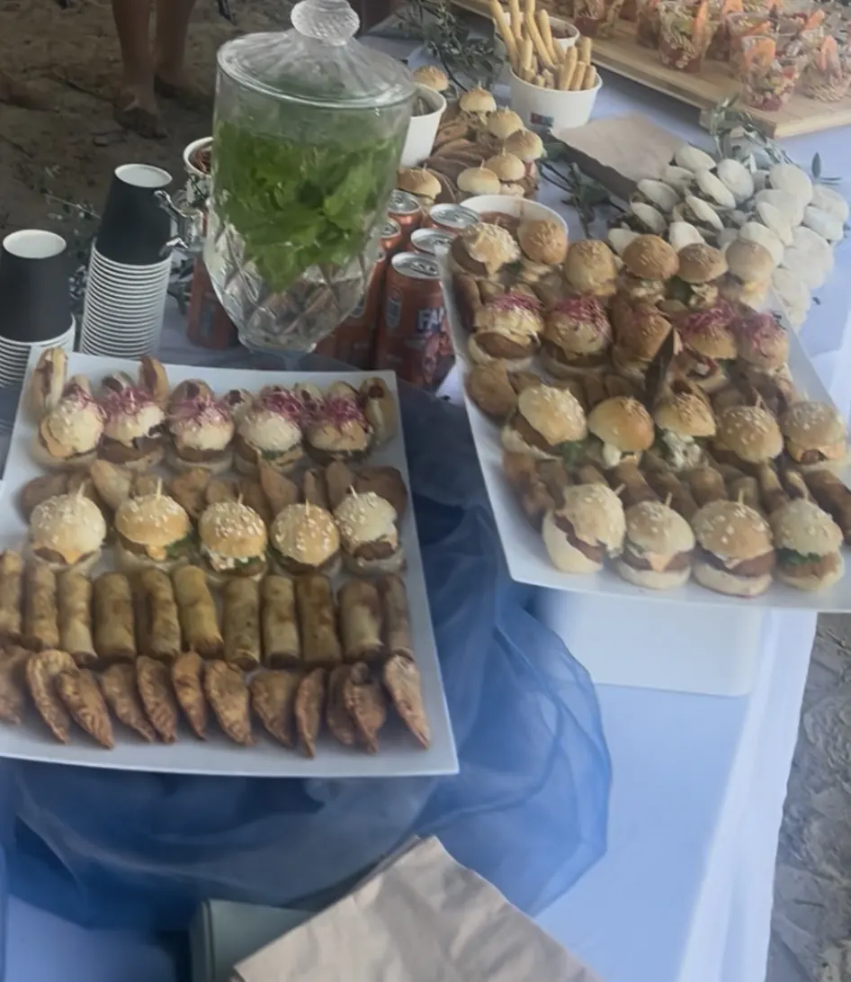 Buffet cocktail dînatoire avec plateaux de mini-burgers, rouleaux croustillants et chaussons