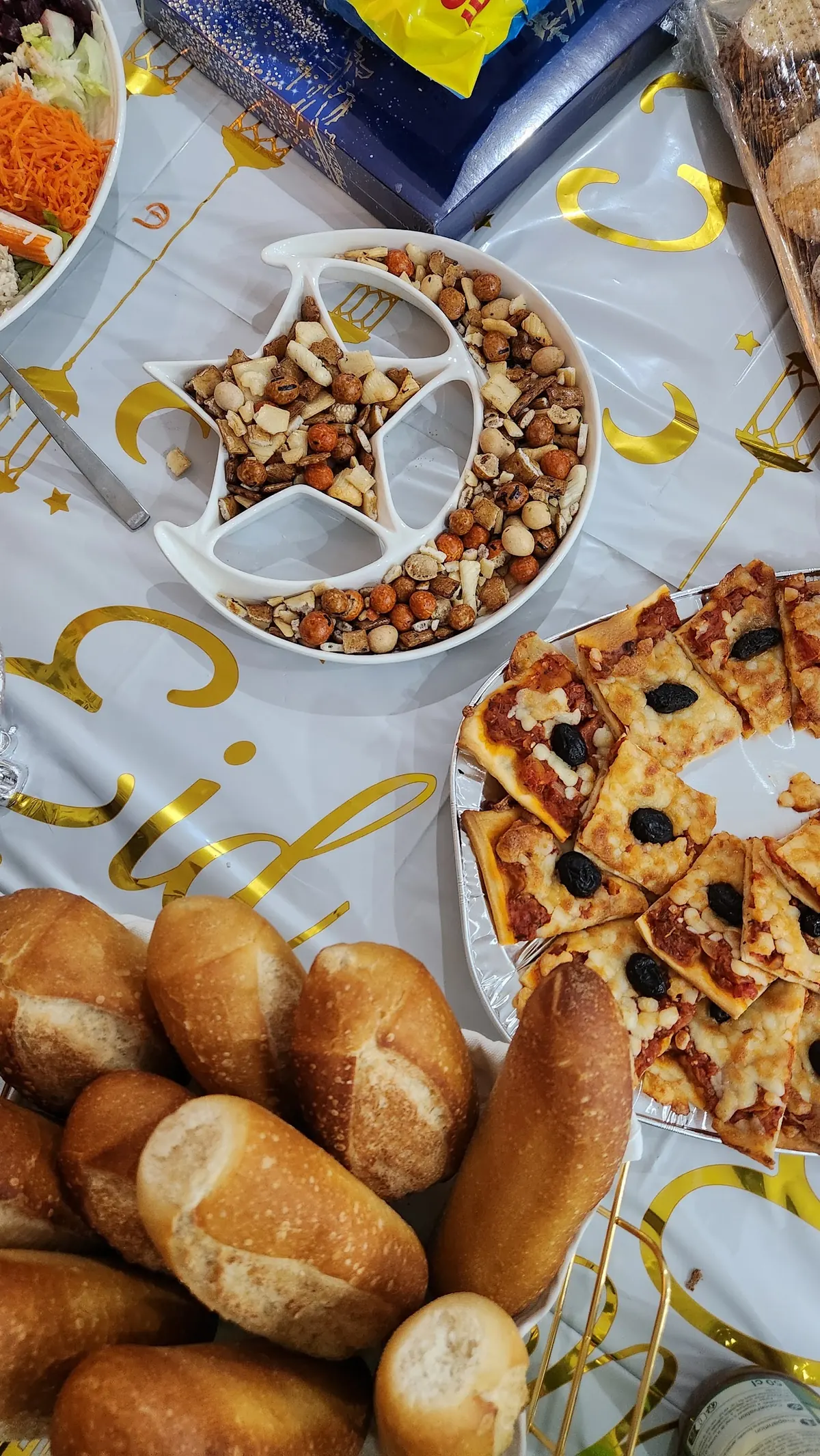 Buffet de fête avec plateau de fruits secs, pizzas maison et petits pains