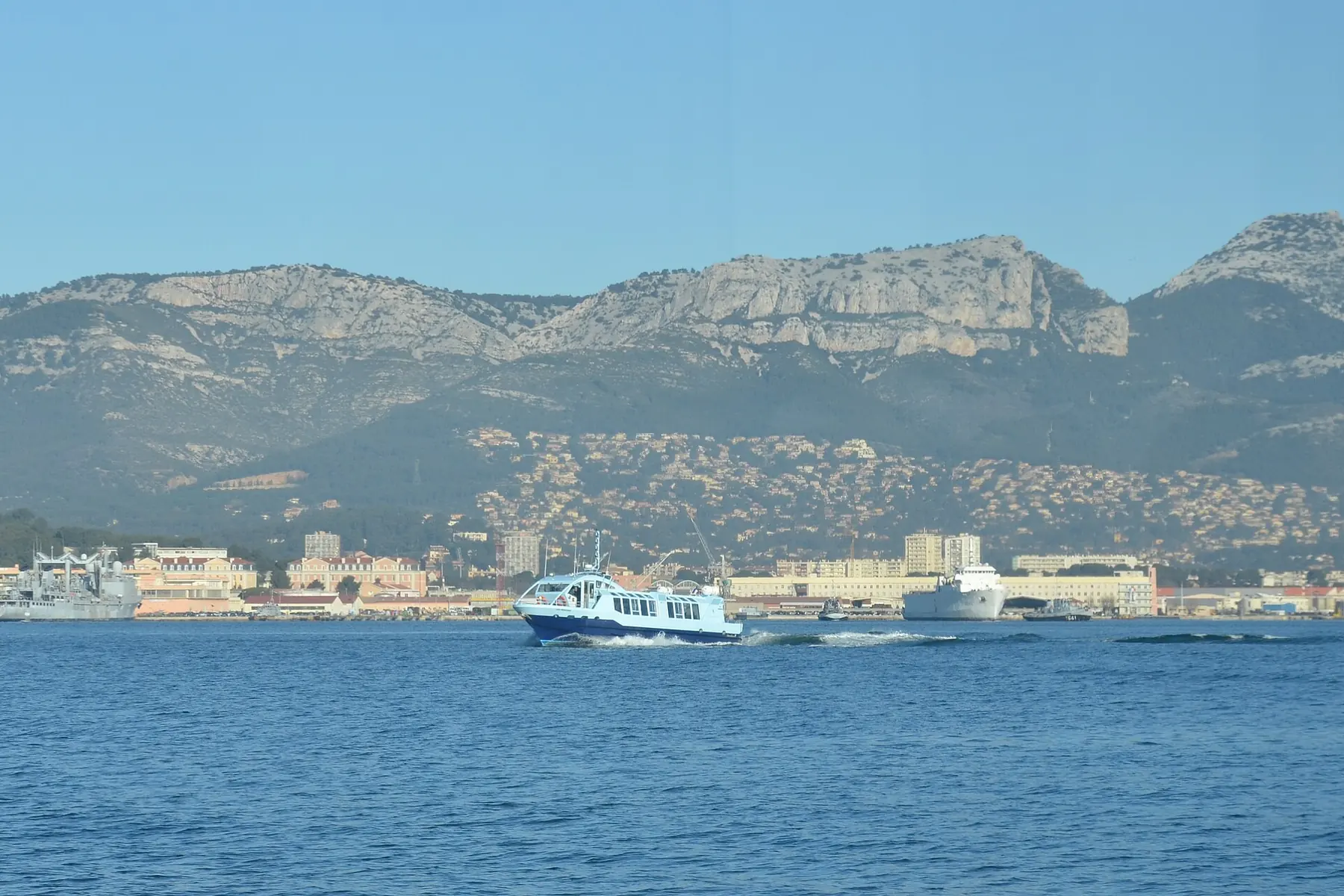 Un bateau-bus dans la petite rade de Toulon, au pied du mont Faron